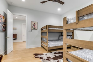 A bunk bed room with a ceiling fan, wooden flooring, and a cowhide rug. - Pool & Lake Access! Dual Homes on Canyon Lake (Canyon Lake)
