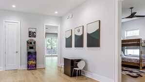 A modern room with a wooden floor, a desk with a chair, bunk beds, and wall art. - Pool & Lake Access! Dual Homes on Canyon Lake (Canyon Lake)