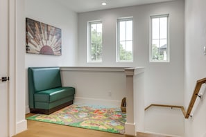 A room with a green sofa, a colorful rug, and three windows. - Pool & Lake Access! Dual Homes on Canyon Lake (Canyon Lake)