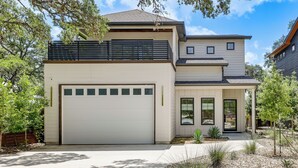 A modern two-story house with a garage, a covered porch, and a landscaped front yard. - Pool & Lake Access! Dual Homes on Canyon Lake (Canyon Lake)