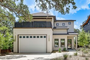 A modern two-story house with a garage, a covered porch, and a landscaped front yard. - Pool & Lake Access! Dual Homes on Canyon Lake (Canyon Lake)