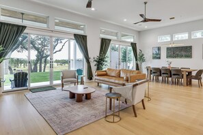 A spacious living room with a large sofa, a coffee table, and a dining area with chairs and a table. - Pool & Lake Access! Dual Homes on Canyon Lake (Canyon Lake)