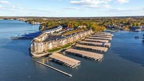 Ein Hotel am Wasserufer mit mehreren Zimmern direkt an den Anlegestellen, einem zentralen Gebäude mit Balkonen und einer Pier, die sich ins Wasser erstreckt.