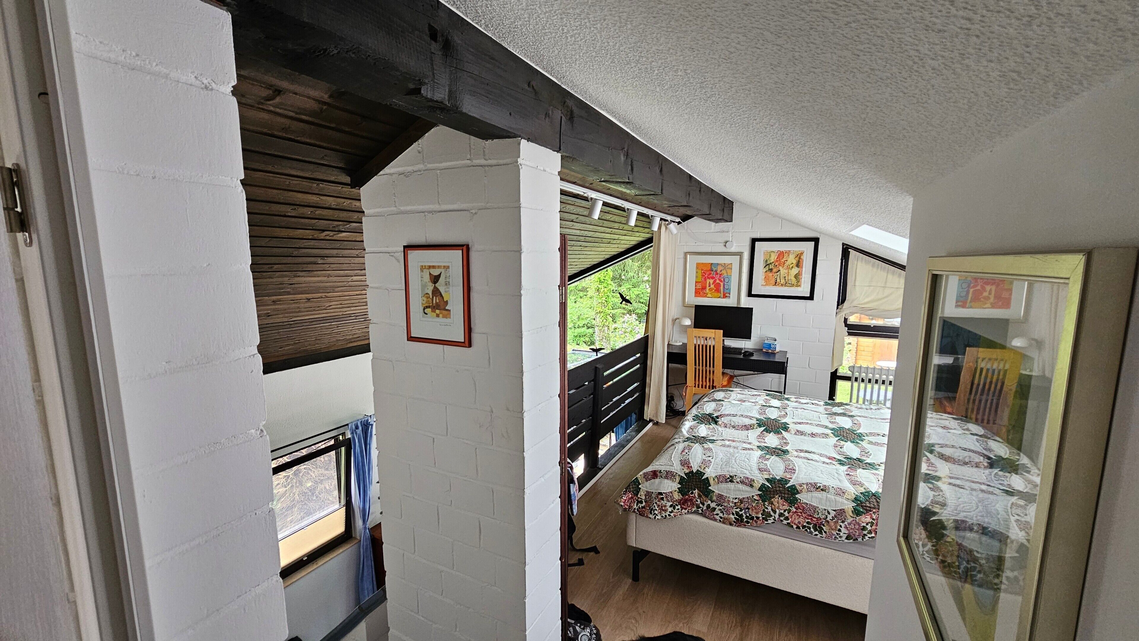 Ein Schlafzimmer mit Bett, Schreibtisch, Stuhl und Fenster.