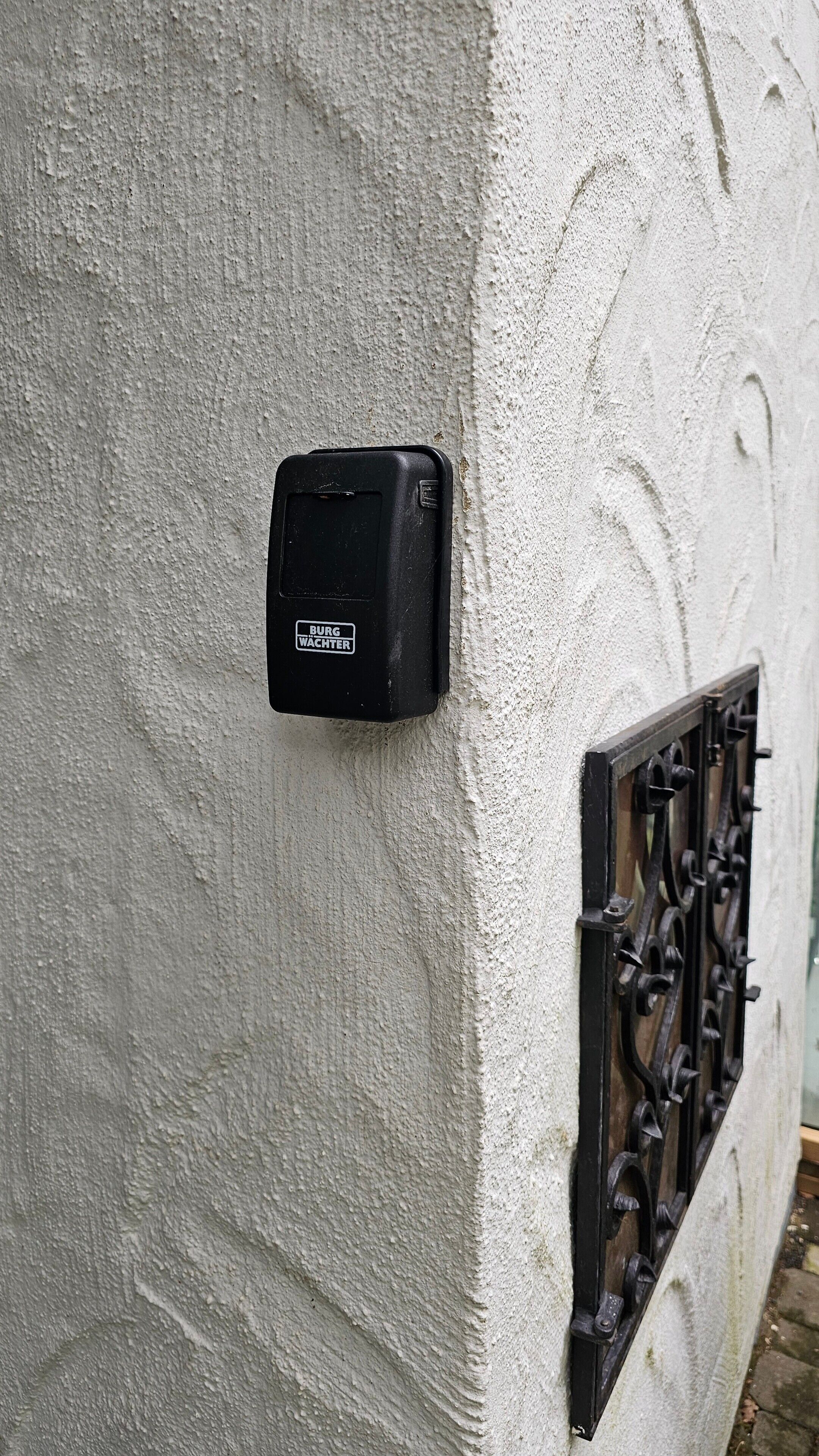 A black electrical box labeled 'BURG WACHTER' mounted on a textured wall.