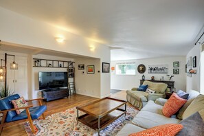 Un salon comprenant un téléviseur, un canapé, une table basse et des objets de décoration.