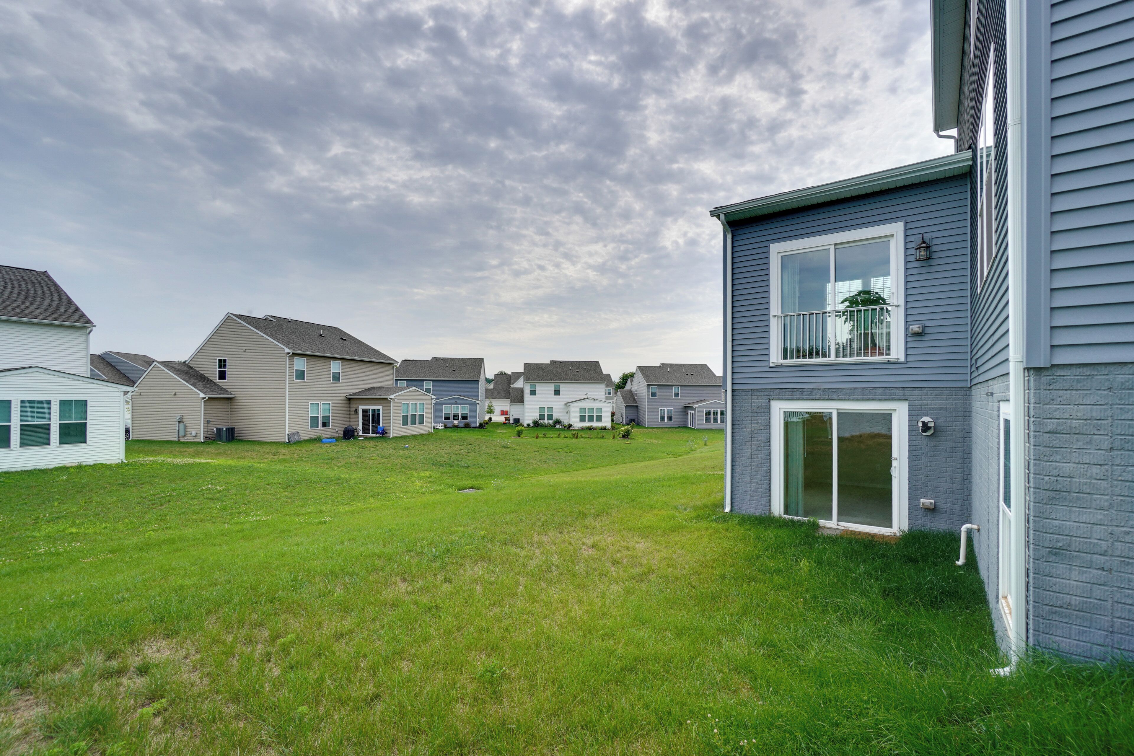 A residential area with houses, a grassy yard, and a clear sky.