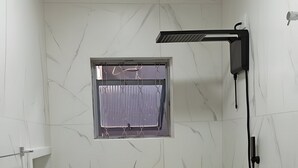 Un baño con inodoro, zona de ducha y ventana con cortina.