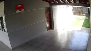 Un pasillo con un cartel de baloncesto, una puerta y vista a un área verde exterior.