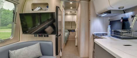Une petite cuisine équipée avec une cuisinière, un évier et des placards de rangement.