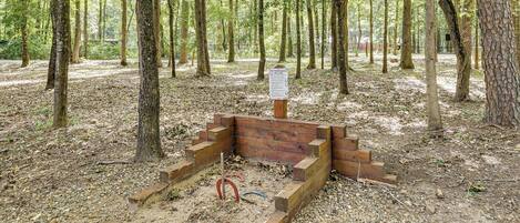 Una estructura de madera en un área boscosa con un cartel que indica las normas sobre herraduras.