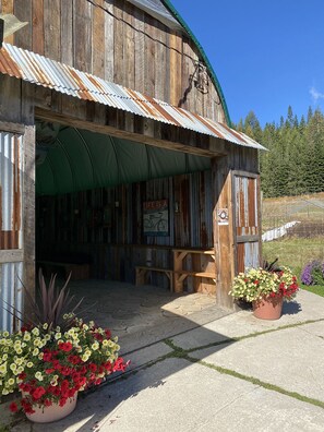 A rustic wooden building with a corrugated metal roof, a covered entrance, and a sign that reads 'Life is a bicycle ride.' - Bear Spring Eco Retreat (Beasley)