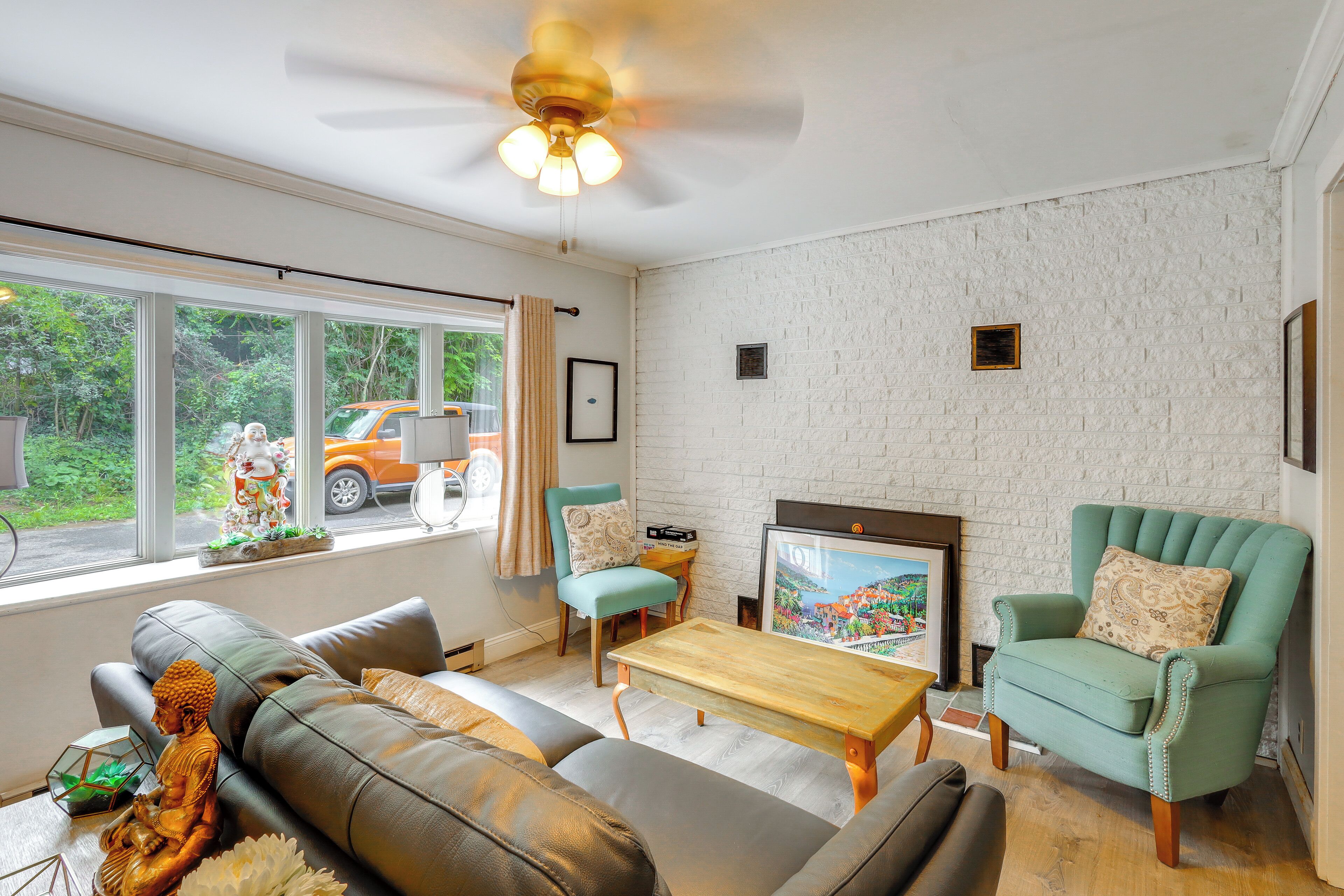 A living room with a sofa, armchairs, a coffee table, and a television.