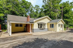 A two-story house with a garage, a chimney, and a small porch. - Home With Water Access: Close to Saratoga (Ballston Lake)