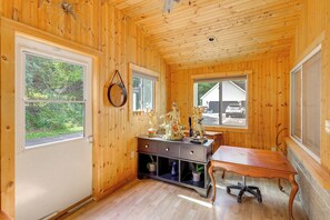 A wooden interior with a desk, chairs, and a window overlooking a vehicle. - Home With Water Access: Close to Saratoga (Ballston Lake)