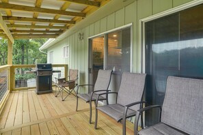 A covered porch with a grill, outdoor seating, and a view of the house's interior.