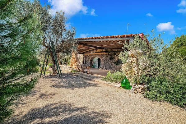 A stone building with a tiled roof, a gravel path, and a green bottle. - Villa Fontanelle Double Room 1 (Ugento)