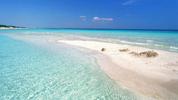 Una spiaggia con acque turchesi cristalline e sabbia bianca.