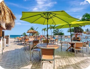 A beachside patio with outdoor seating and umbrellas. - Beach Days & Sunset Nights in Fort Lauderdale (Fort Lauderdale)