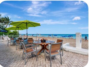 A beachside patio with outdoor seating and umbrellas, overlooking the ocean. - Beach Days & Sunset Nights in Fort Lauderdale (Fort Lauderdale)