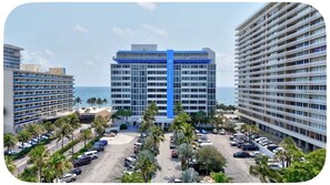 Elevated view overlooking coastal high-rises, palm-lined parking, and the ocean. - Beach Days & Sunset Nights in Fort Lauderdale (Fort Lauderdale)