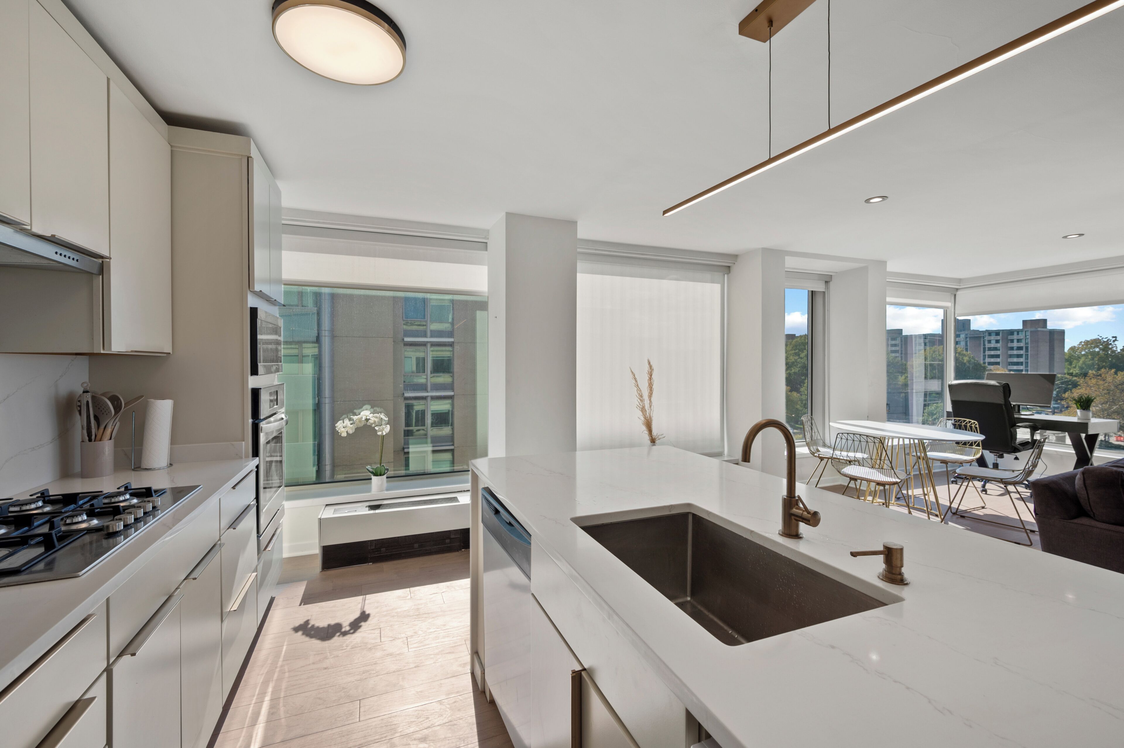 A modern kitchen with a large island, stainless steel appliances, and a view of the city.