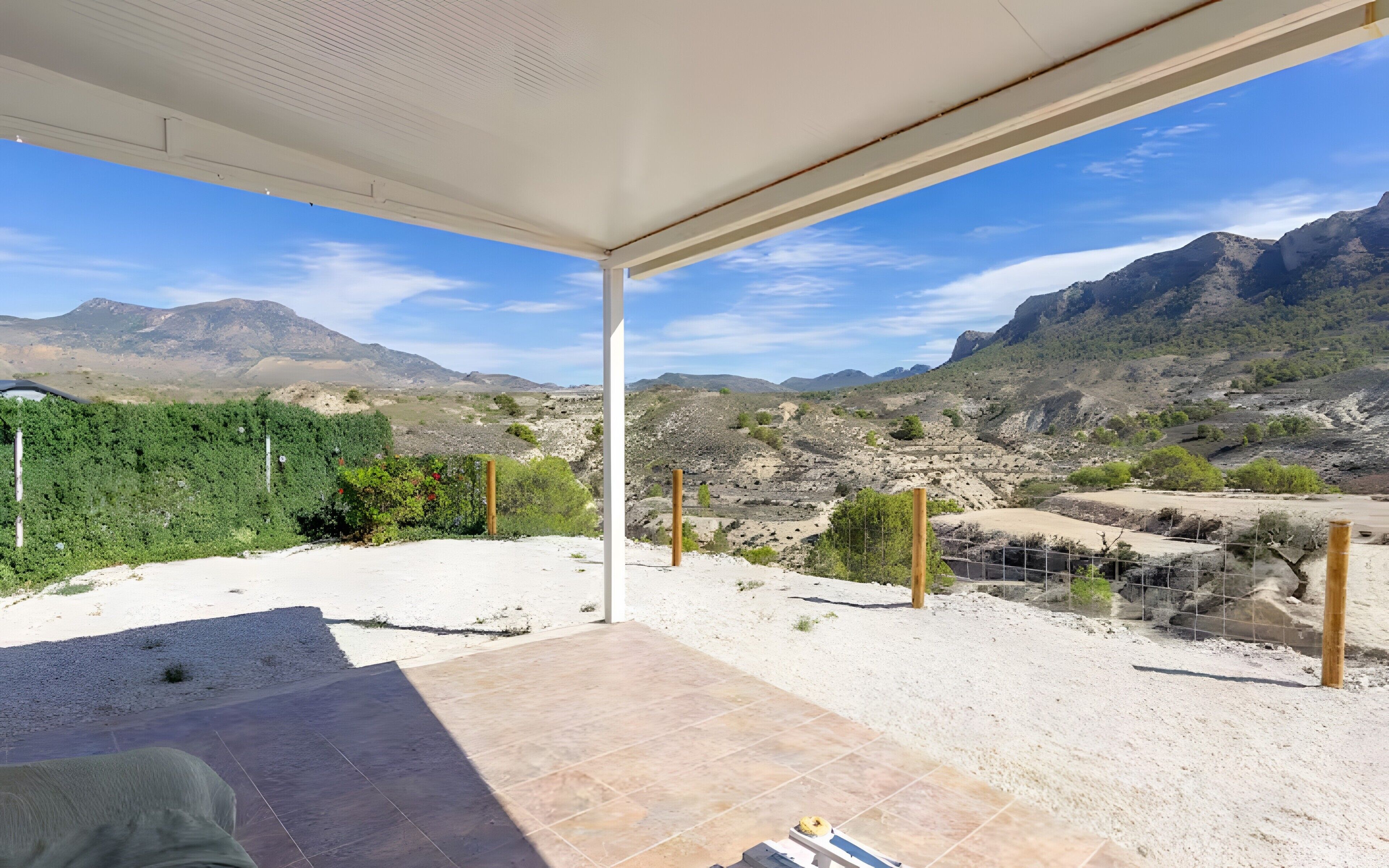 A room with a view of a mountainous landscape, a tiled floor, and a white ceiling.