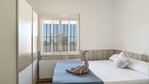 A bedroom with a bed, a window with bars, and a radiator. - Chalet 'Los Majales' with Private Pool, Wi-Fi, and Air Conditioning (Molina de Segura)