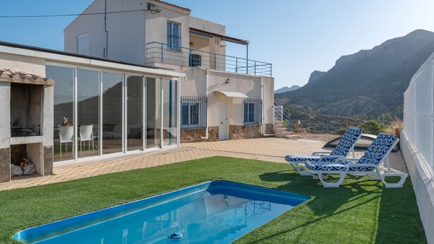 A modern villa with a swimming pool, outdoor seating, and a mountain view. - Chalet 'Los Majales' with Private Pool, Wi-Fi, and Air Conditioning (Molina de Segura)