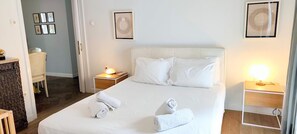 Ein Hotelzimmer mit einem Bett, zwei Nachttischen und einem Sessel.