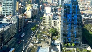 Un paisaje urbano con edificios altos, cielo despejado y un río.