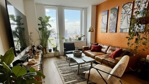 Una sala de estar moderna con un sofá, una mesa de centro y plantas en macetas.