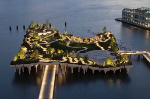 An aerial view of a waterfront property with a central landscaped area, pathways, and a dock. - Beauty In the Heart of the Village (New York)