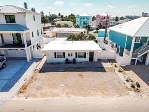 A multi-story residential building with a flat roof, a covered parking area, and a clear view of the surrounding neighborhood. - Sunshine Nook - 1/2 Block to the Beach (Fort Myers Beach)