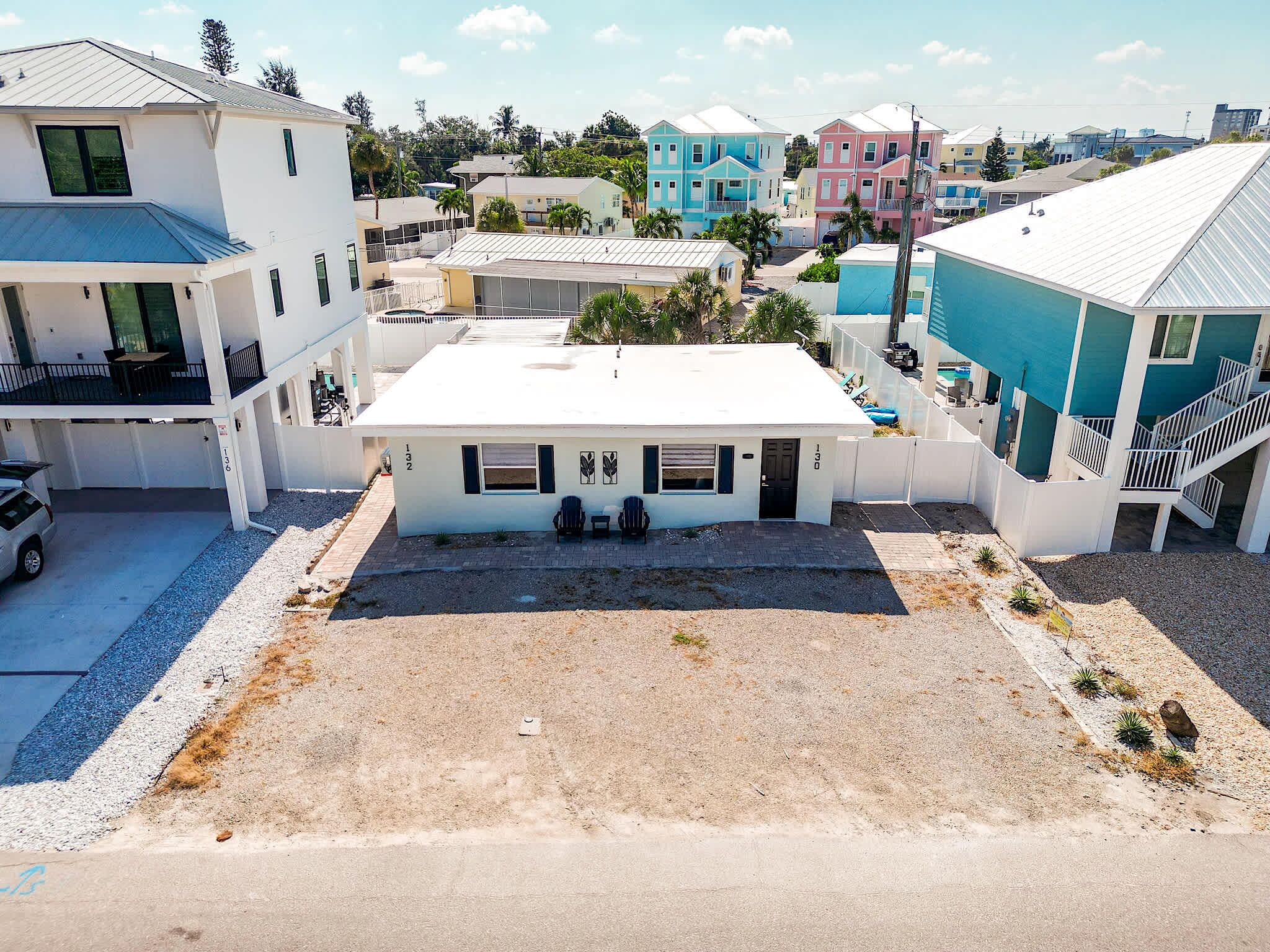 A multi-story residential building with a flat roof, a covered parking area, and a clear view of the surrounding neighborhood.