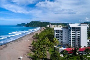A coastal hotel with a beach view, multiple floors, and a pool area. - Oceanfront 3BR | Sunset Views | Diamante del Sol (Jacó)