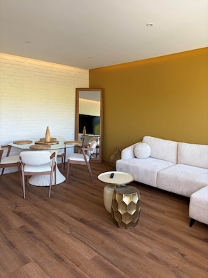A modern living room with a sofa, chairs, a glass table, and a decorative mirror. - Le Balcon de Sarlat * Private parking & Town center 25 meters away (Sarlat-la-Canéda)