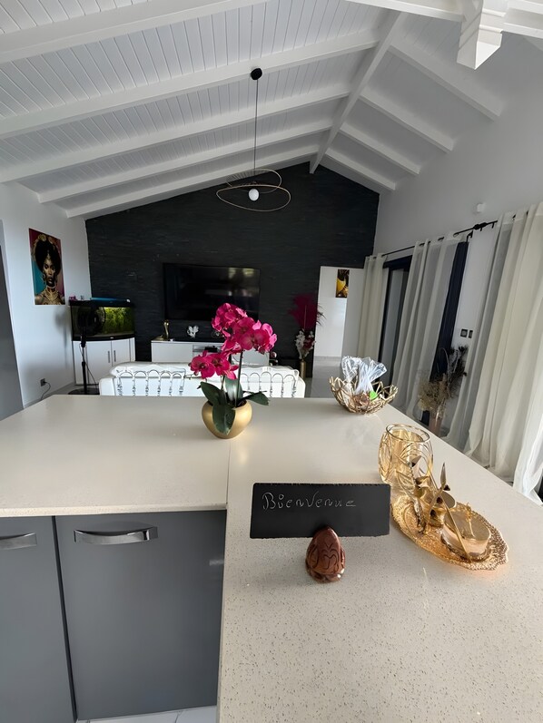 A modern kitchen with a central island, a blackboard sign, and decorative items.