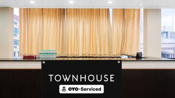 A reception desk with a sign that reads 'TOWNHOUSE OYO-Serviced.'