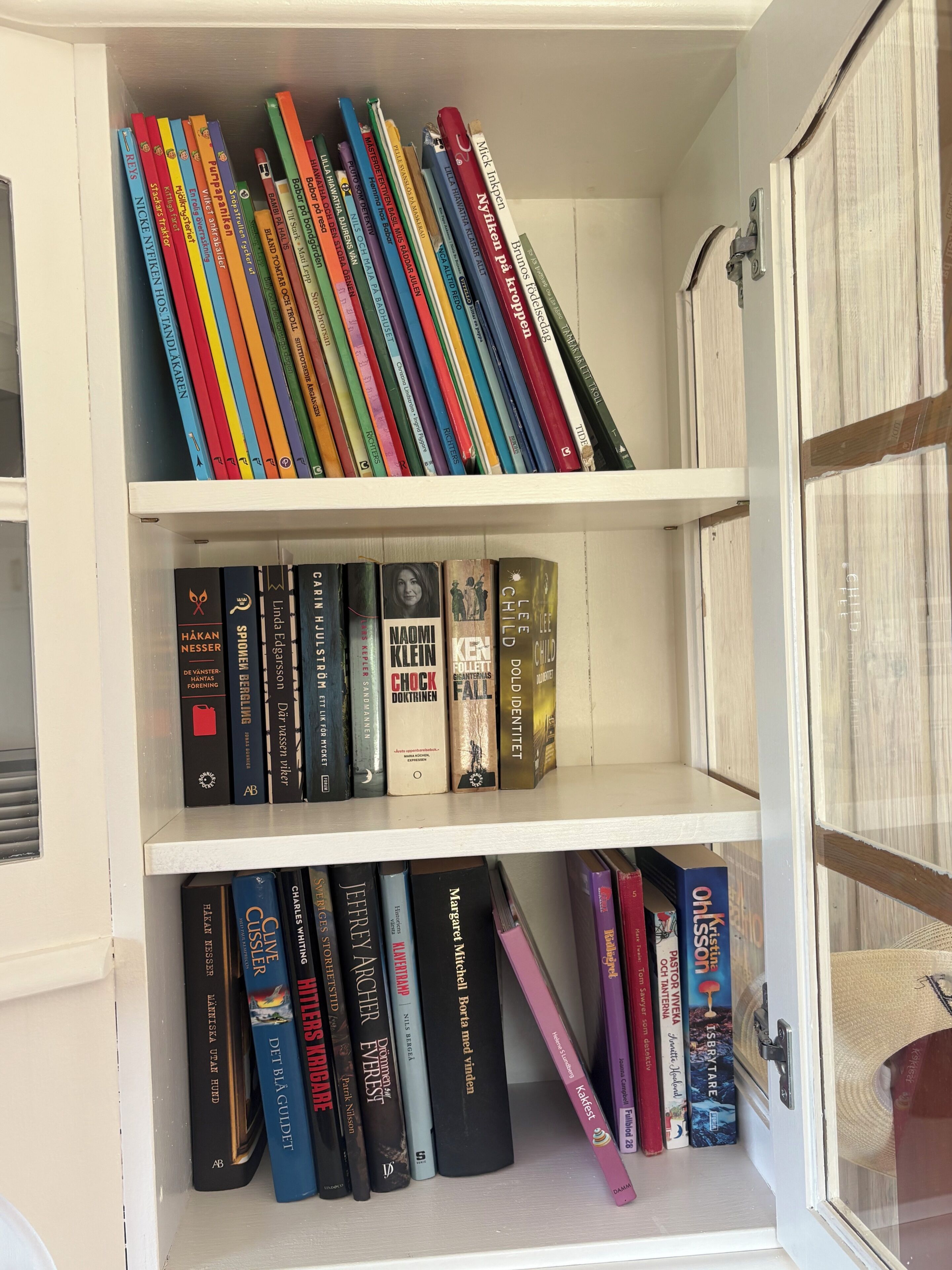 A bookshelf with various books and a door with a lock.