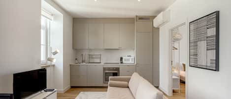 A modern apartment with a living room, kitchenette, and a dining area.