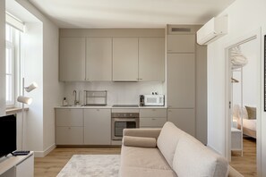 Una cocina compacta con horno integrado, microondas y cafetera.