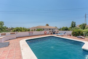 A swimming pool with a tiled deck, a lifebuoy, and a sign with symbols. - Apartment 'Casa Luz' with Sea Views (Benalmádena)