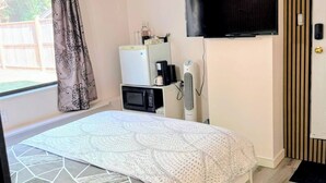 Makuuhuoneessa on sänky, televisio, mikroaaltouuni ja jääkaappi.