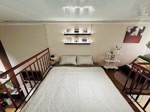 A bedroom with a bed, a nightstand, a shelf with books, a small table, and a chair. - Cozy Vibe Home just short walk to Hoan Kiem Lake, bathtub, kitchen, max 6 guests (Hà Nội)