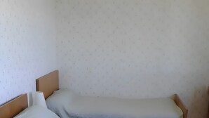 En säng för en person med en sänggavel och en fotgavel, en kudde och ett täcke.