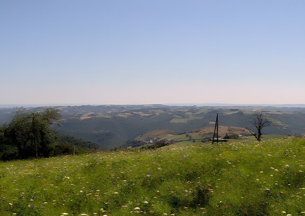 A panoramic view of a hilly landscape with a clear sky.