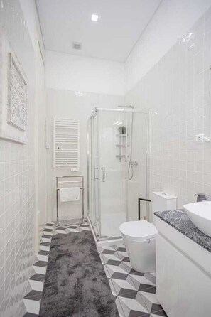A modern bathroom with a shower, toilet, and sink. - Charm in Porto, located in the heart of Porto's most famous street (Porto)