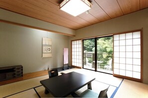 A traditional Japanese room with tatami flooring, a sliding door leading to a balcony, and a low table with chairs. - Hakone Shiunso (Hakone)