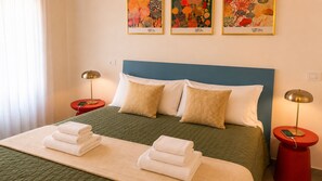 A hotel room with a bed, two bedside tables, a lamp on each table, and artwork on the wall. - Dorsoduro Venice Loft by Venicescape (Venezia)